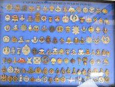 Collection of one hundred and thirty cap badges in glazed frame, captioned 'Cap Badges of WW2 1939-