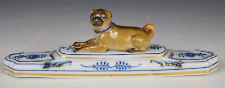 Meissen figural pug dog paperweight with blue and gilt collar, raised on a stepped base, blue
