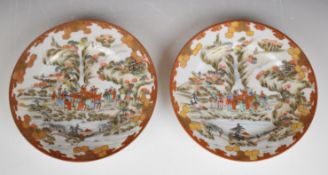 Pair of Japanese Kutani plates decorated with figures picnicking beside a river, with eight