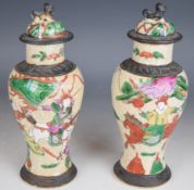 A pair of Chinese crackle glazed lidded vases decorated with Samurai warriors on horseback, height