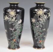 A pair of Japanese cloisonné enamel vases with decoration of birds, flowers and foliage on navy blue