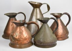 Four copper one gallon measuring jugs and a two gallon galvanised or similar example, tallest 36cm