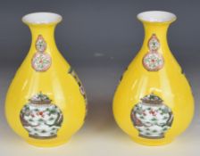 Pair of yellow Chinese porcelain vases with enamelled decoration of various Chinese antique vases,