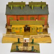 Hornby 0 gauge tinplate engine shed together with Windsor station platform and level crossing.