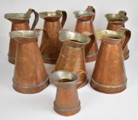 Seven copper half gallon / four pint jugs and a one pint example, tallest 25cm