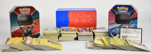 A quantity of modern Pokémon cards, housed in three collector tins/boxes.