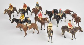 Twelve Britains painted metal racehorses accompanied by nine jockeys in racing colours.