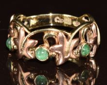 A yellow metal Clogau ring in a foliate decoration set with emerald cabochons, in original box, 3.