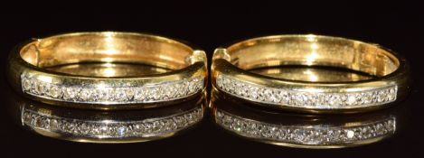 A pair of 18ct gold hoop earrings each set with thirteen round cut diamonds, the total diamond