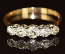 An 18ct gold ring set with five diamonds in a platinum setting, the largest diamond approximately