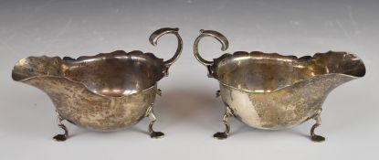 Pair of Edward VII or George V hallmarked silver sauce boats with shaped edges, scroll handles and