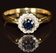 An 18ct gold ring set with a round cut sapphire surrounded by diamonds, 2.8g, size P