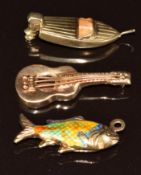 Three 9ct gold charms one in the form of a boat, one a guitar and the other a fish set with