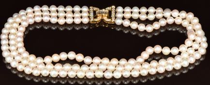 A three strand cultured pearl necklace, the 18k gold clasp set with baguette and round cut diamonds,