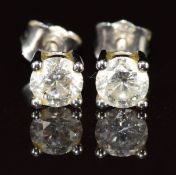 A pair of 9ct white gold earrings each set with a round cut diamond, of approximately 0.25ct, 0.8g