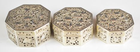 Three Chinese, Burmese or similar octagonal silver trinket pots with pierced lids decorated with
