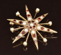 A 9ct gold star brooch set with pearls and garnets, 7g, 4cm