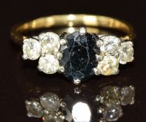 An 18ct gold ring set with an oval cut sapphire and six diamonds, the total diamond weight