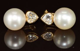 A pair of 18k gold earrings each set with a South Sea pearl of approximately 10.9mm and a heart