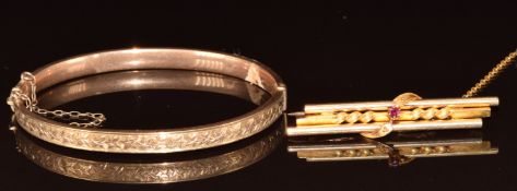 A 9ct rose gold bangle with ivy decoration (5.7g) and a 15ct gold brooch set with a ruby (4.7g)