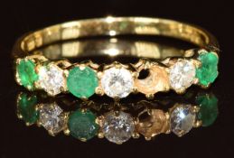 An 18ct gold ring set with round cut diamonds and emeralds, each approximately 0.15ct (one emerald