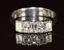 A 14k white gold ring set with three emerald cut diamonds of 0.4ct, 0.35ct and 0.35ct and four