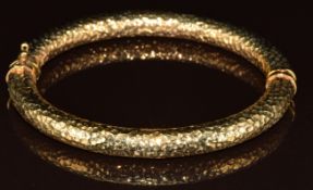 A 9ct gold bangle with hammered decoration, 13.6g, 6.4 x 5.4cm