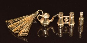 Four 9ct gold charms comprising bottle, coffee pot, fan and binoculars, 6g
