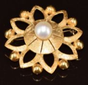 An 18ct gold brooch with textured decoration and set with a pearl to the centre, 9.8g, 3.4cm