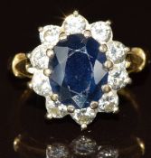 An 18ct gold ring set with an oval cut sapphire of approximately 1.8ct surrounded by diamonds, the