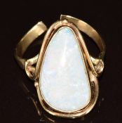 A 9ct gold ring set with a white opal cabochon (band cut), 5.6g