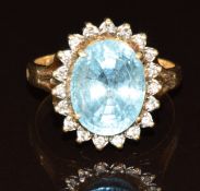 A 14k gold ring set with an oval cut topaz surrounded by diamonds, 6.5g, size Q