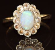 A 9ct gold ring set with an opal cabochon surrounded by zircons, 2.2g, size L
