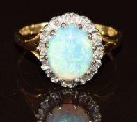 An 18ct gold ring set with an oval cut opal cabochon surrounded by diamonds, 4.5g, size O