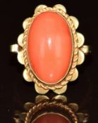 A 14k gold ring set with a coral cabochon, 4.4g, size L