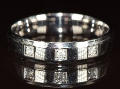 A 9ct white gold ring set with three diamonds in square settings, 4.3g, size T/U
