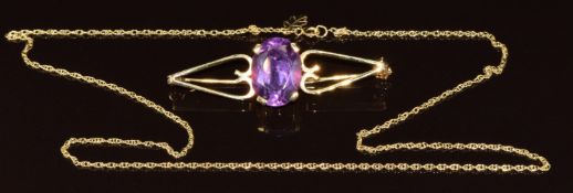 A yellow metal brooch set with an oval cut synthetic purple colour change sapphire (7.2g, 4.8cm) and