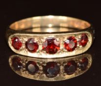 A 9ct gold ring set with five round cut garnets, 3.7g, size Q