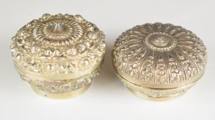 Two Chinese, Burmese or similar silver trinket pots with embossed decoration, the largest having