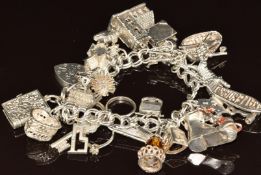 Silver charm bracelet with twenty two silver charms including coracle, Welsh love spoon, hedgehog,