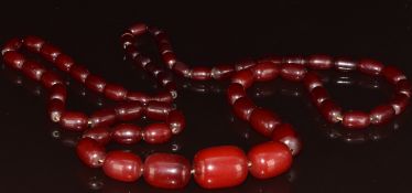 Cherry amber necklace made up of sixty one graduated barrel shaped beads, the largest 27 x 20mm