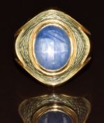 An 18k gold ring set with a star sapphire cabochon with an enamel border, 15.9g, size Q