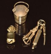 Three 9ct gold charms / pendants, one in the form of a sweet, one a bucket and the other cooking