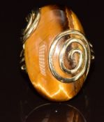 A 9k gold ring set with a tiger's eye cabochon, with swirl decoration, 10.1g, size P