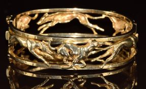 A 9ct gold bangle in the form of racing greyhounds, made by Harriet Glen, 40.3g, 6.2 x 5.7cm