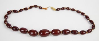 Cherry amber necklace of graduated beads, the largest 15.5 x 21.7mm and smallest 6.5 x 9.8mm, 23.7g