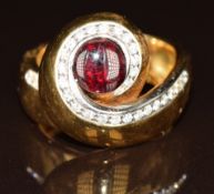 An 18ct gold ring set with a garnet and diamonds in a twist setting by Gio Caroli, 16.5g, size N/O