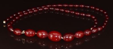 Cherry amber necklace made up of 58 graduated oval beads, the largest bead 21 x 27mm, smallest