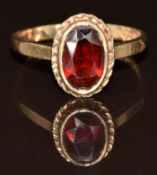 A 9ct gold ring set with an oval garnet, 2.7g, size O