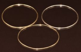 Two 9ct gold bangles and one yellow metal bangle, 13.9g, 5.7cm